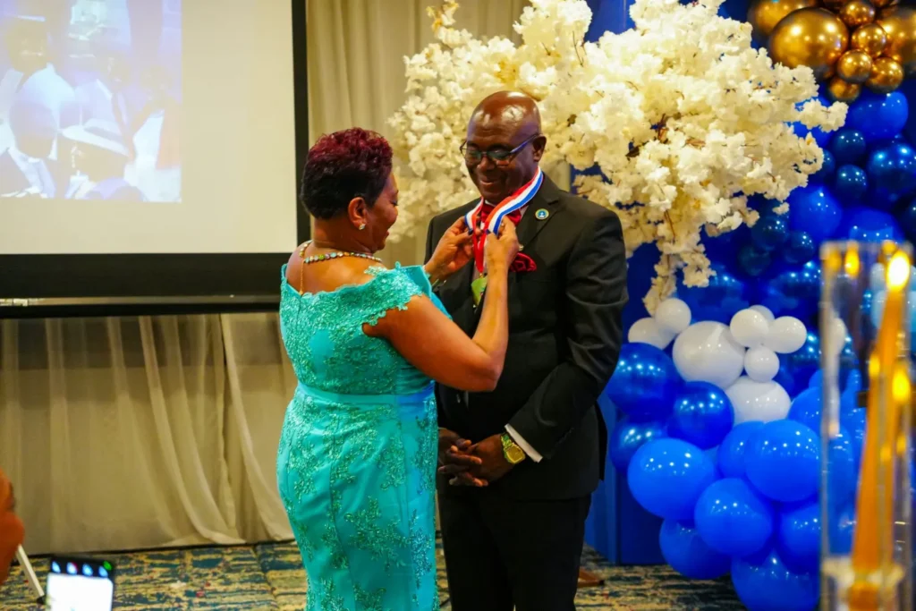 Bishop Donald McFarlane smiles as he is presented with a medal at the celebration of his 40 years of pastoral ministry.