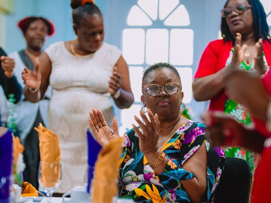Guests standing and clapping in worship at the NFCM Prayer Breakfast 2026.