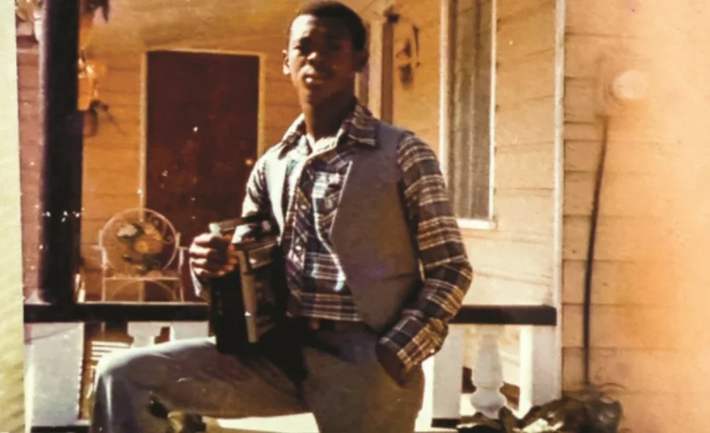 A young Donald McFarlane standing on a porch