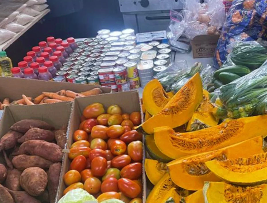 Boxes of sweet potatoes, tomatoes, pumpkin and canned goods ready for The Pantry