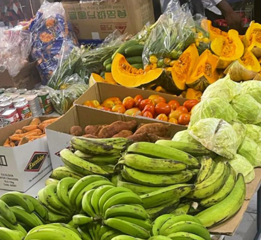 Green bananas, cabbage, pumpkin and tomatoes laid out for Pantry families