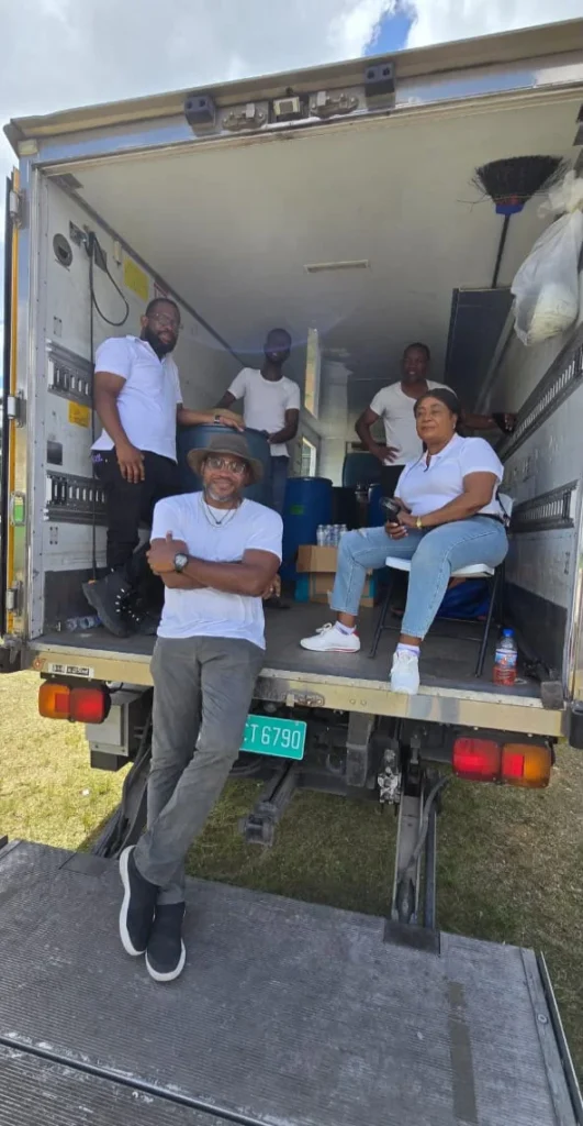 Members of the NFCM outreach team gather in and around the supply truck loaded with water and supplies.